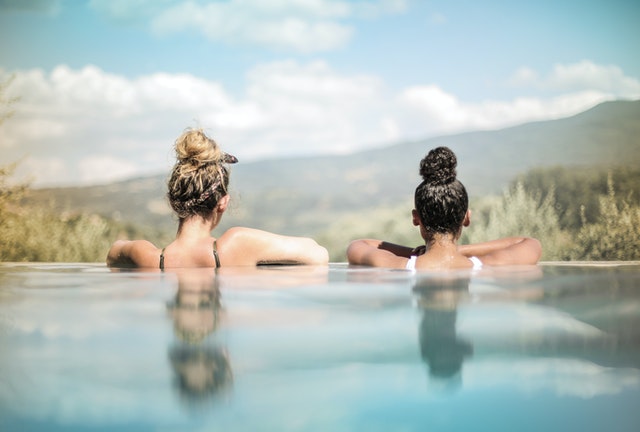 две жени стоят на ръба на басейн