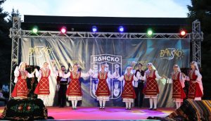 Фолклорен ансамбъл изпълнява традиционни български танци на сцена на фестивал