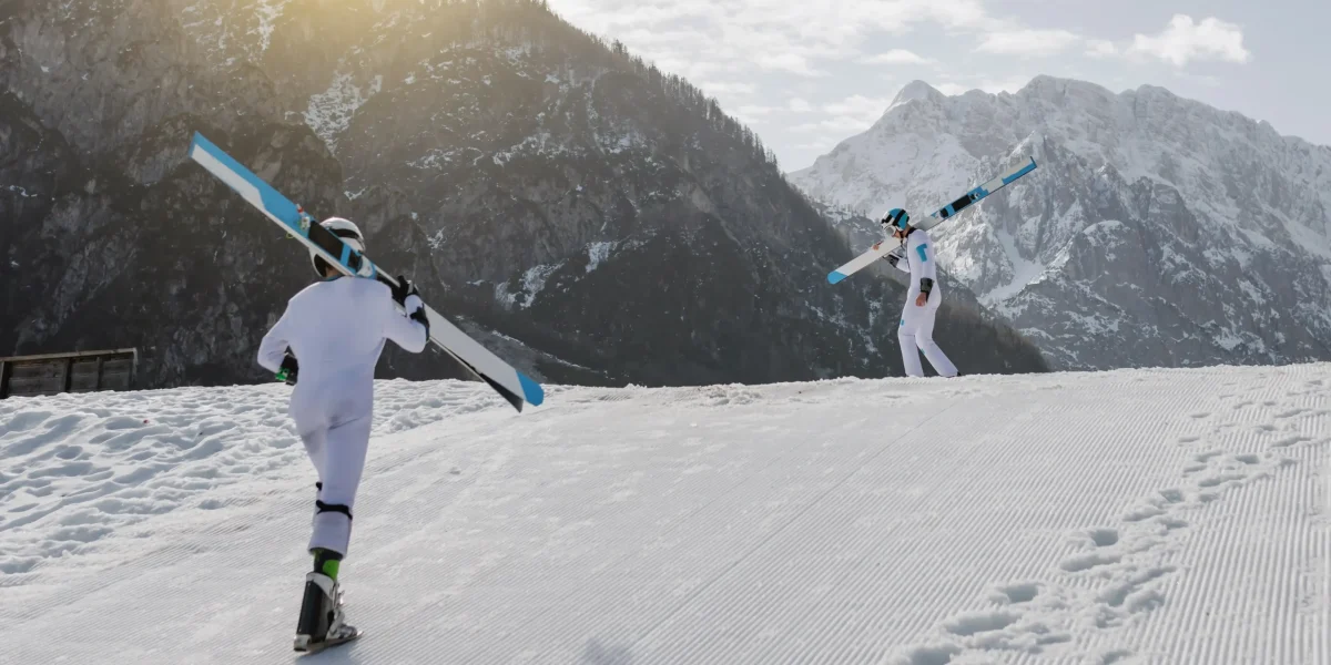 two-ski-jumpers-walking-across-ski-slope-with-skis-his-shoulder-beautiful-winter